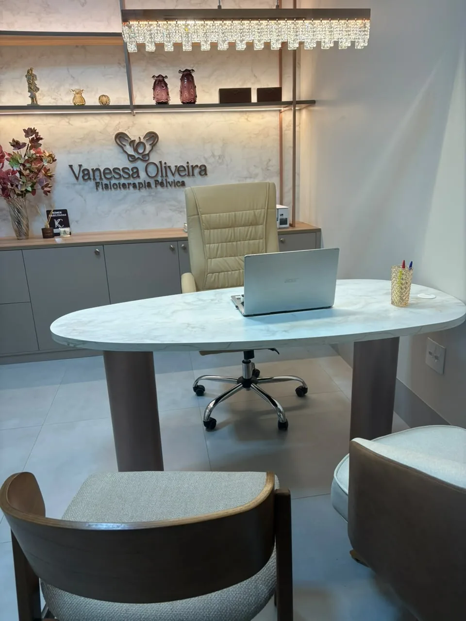 Consultório da Dra. Vanessa Oliveira, com mesa de atendimento e poltronas
