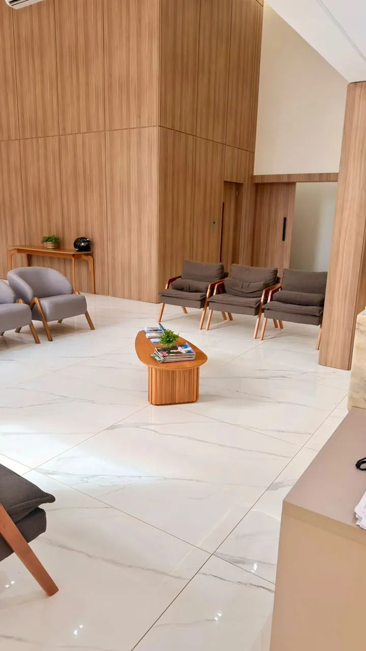 Ambiente de espera da Galileo Clinic, com poltronas e revestimento em madeira